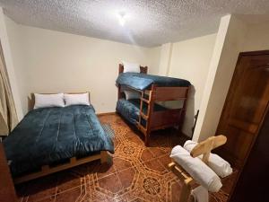 a small room with a bed and a bunk bed at Granja Doña Carmelita in Ibarra