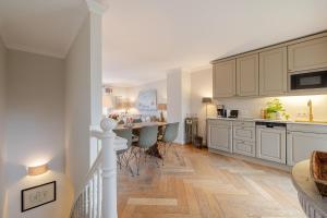 a kitchen with white cabinets and a table and chairs at Deichgraf 4 in Kampen