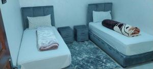 two beds sitting next to each other in a room at rooms maissa 1 in Cabo Bojador
