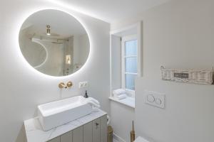 a white bathroom with a sink and a mirror at Deichgraf 4 in Kampen