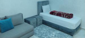 a small bedroom with a bed and a couch at rooms maissa 1 in Cabo Bojador