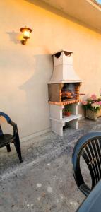 a outdoor pizza oven sitting next to a wall at Moradia santa comba in Santa Comba Dão