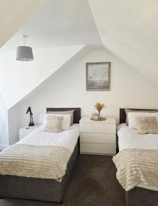 two beds in a bedroom with white walls at The Coal House in Townhill