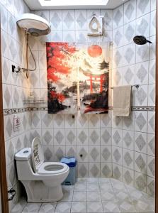 a bathroom with a toilet and a painting on the wall at Your Home In Riyadh Hostel in Riyadh +23 photos