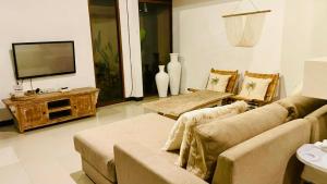 a living room with a couch and a flat screen tv at Villa Searenity Seminyak in Seminyak