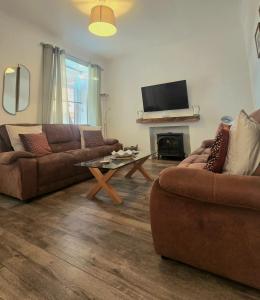 a living room with two couches and a fireplace at The Coal House in Townhill