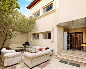 a patio with couches and a table in front of a building at Your Home In Riyadh Hostel in Riyadh
