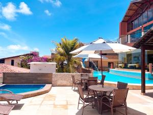 a patio with tables and chairs next to a swimming pool at Planet Dunas in Aquiraz