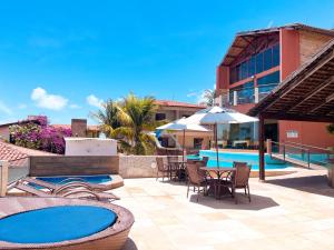 a patio with tables and chairs and a swimming pool at Planet Dunas in Aquiraz