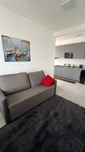 a living room with a couch and a kitchen at Doce Lar 2 in Pouso Alegre