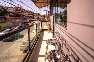 a balcony of a building with two stools at Refúgio Black in Sabará
