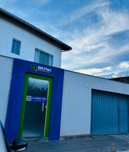 a building with a blue and green door at VOER - BR Flat Hospedaria in Sete Lagoas