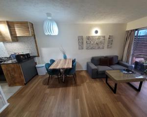 a living room with a table and a couch at A-Frame Chalets @ Mokutu in Burnt Pine