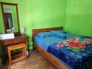 a bedroom with a bed and a dresser and a mirror at Wisma PO'ONG in Ruteng