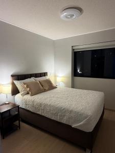 a bedroom with a bed and a large window at Brand New Apartment in Lima