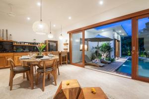 an open kitchen and dining room with a dining table and a pool at Villa Jacelyne - Tropical 2BR Villa with Private Pool in Canggu in Dalung