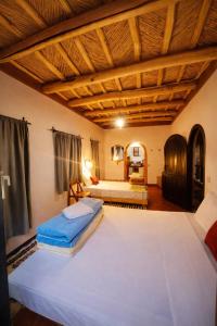 a bedroom with two beds and a wooden ceiling at Riad pizzeria Marhaba in Akhendachou nʼAït Ouffi