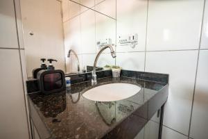 a bathroom with a sink and a mirror at Refúgio Black in Sabará +16 photos