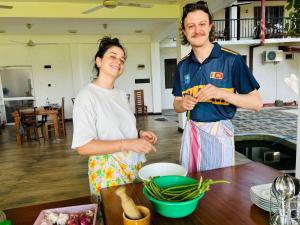 a man and woman standing in a kitchen preparing food at Man Guest Polonnaruwa in Polonnaruwa