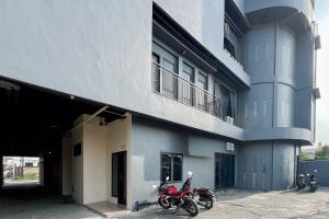 two motorcycles parked in front of a building at SANS Vibes Millenium Inn Medan in Pulauberayan