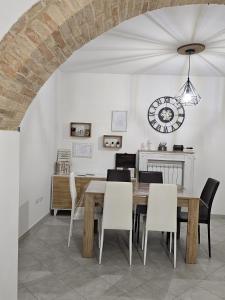 a dining room with a table and chairs and a clock at I Tre Mori in Recanati +12 photos