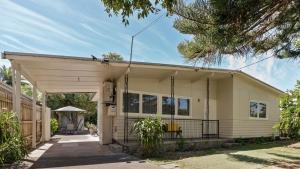 a small white house with a garage at The Ocean Gem at Rosebud with its own Private Beach Box in Rosebud