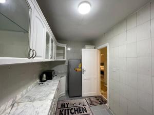 a kitchen with a white tiled floor and a refrigerator at Golden House Madinty in Madinaty +85 photos