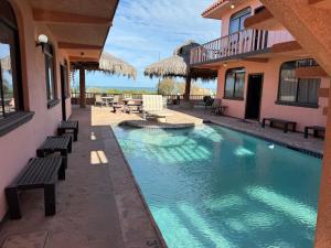 a swimming pool with benches next to a house at Ocotillo del Mar in San Felipe