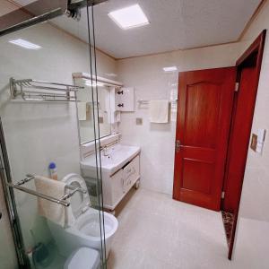 a bathroom with a toilet and a sink and a red door at 青云小栈 in Shaoxing +14 photos