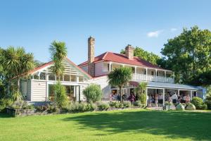 a group of people standing on the porch of a house at Quest Henderson, Auckland Apartment Hotel in Auckland