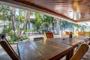 a wooden table and chairs in a patio with trees at Chapalita Grand House in Guadalajara