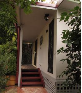a porch of a house with stairs and a door at Dees Rear Studio Room in Hazelbrook