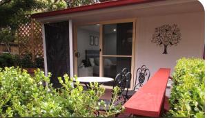 a patio with a table and a bench on a house at Dees Rear Studio Room in Hazelbrook +1 photo