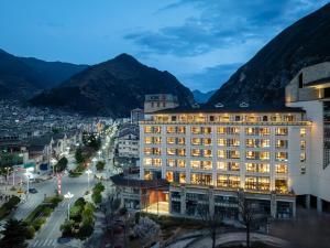 a view of a building with mountains in the background at Jiuzhaigou A HOTEL in Jiuzhaigou +11 photos