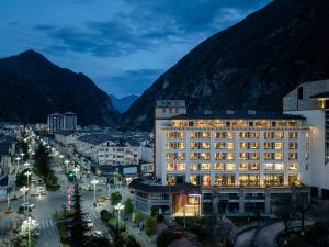 a hotel in a city with mountains in the background at Jiuzhaigou A HOTEL in Jiuzhaigou
