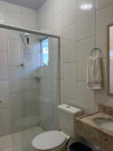 a bathroom with a toilet and a shower and a sink at Hotel Entre Lagos in São José do Cerrito