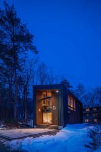a house with a glass door at night at Kairos by the Mountain in Hakuba