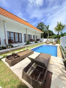 a villa with a swimming pool and a house at Bayedan Homestay in Badung