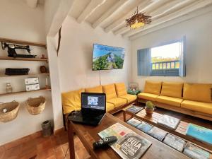 a living room with a couch and a table with a laptop at Casa Quintanilla Barichara in Barichara