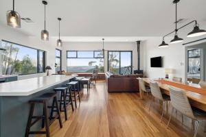 a kitchen and living room with a bar and chairs at Sunset Retreat in Mount Victoria