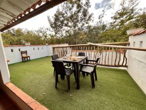 a patio with a table and chairs on a balcony at Casa Quintanilla Barichara in Barichara