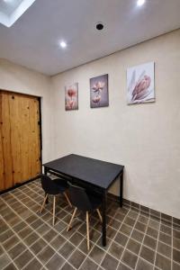 a table in a room with three pictures on the wall at Origami in Palmas