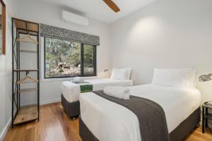 two beds in a room with a window at Sunset Retreat in Mount Victoria