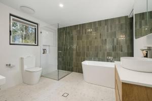 a bathroom with a tub and a sink and a toilet at Sunset Retreat in Mount Victoria +15 photos