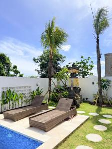 a backyard with two chairs and a swimming pool at Bayedan Homestay in Badung