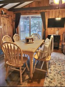 a wooden table and chairs in a room at WILDFLOWER CABINS LIMIT 6 villa in Naples