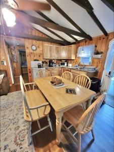a kitchen with a wooden table and chairs at WILDFLOWER CABINS LIMIT 6 villa in Naples