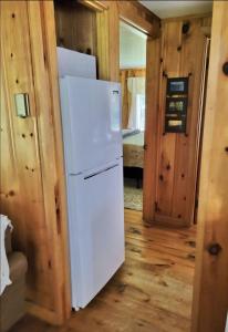 a white refrigerator in a room with a bedroom at WILDFLOWER CABINS LIMIT 6 villa in Naples +24 photos