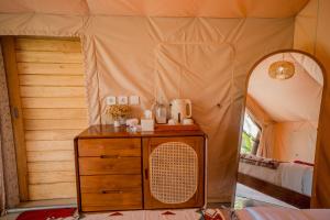 a room with a wooden dresser in a tent at MaHe Glamping in Kubupenlokan