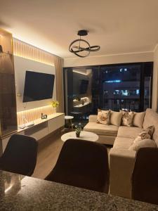 a living room with a couch and a flat screen tv at Brand New Apartment in Lima